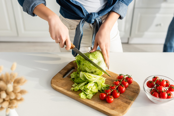 cropped view of woman cutting lettuce on chopping board - 写真・画像