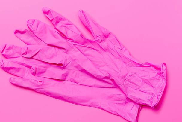 Pink latex gloves to protect against viruses and bacteria. Pink background. - Foto, afbeelding
