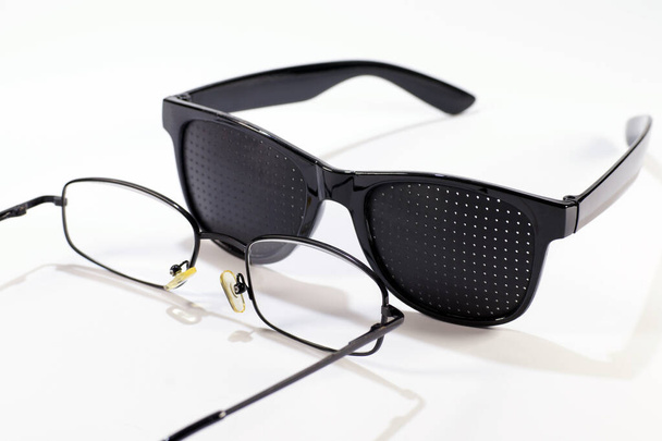 Deux paires de lunettes. Lunettes à trou d'épingle versus lunettes classiques. - Photo, image