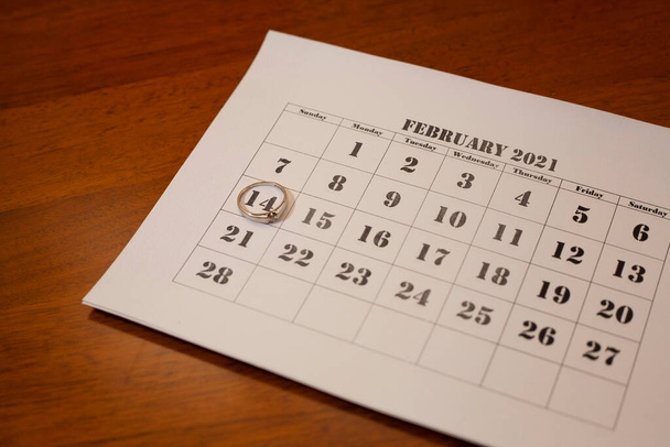 Kalender waarop de datum 14 februari valt. Valentijnsdag. Trouwring op de kalender. - Foto, afbeelding