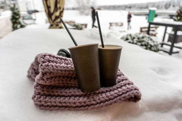 Deux tasses en papier avec café garder au chaud sur une écharpe dans la neige, conte d'amour d'hiver - Photo, image