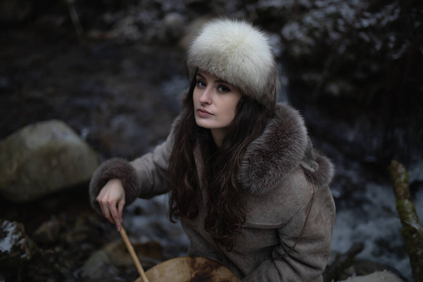 Portrait of a woman wearing fur hat and leather jacket.Shot in forest surroundings. - Photo, Image