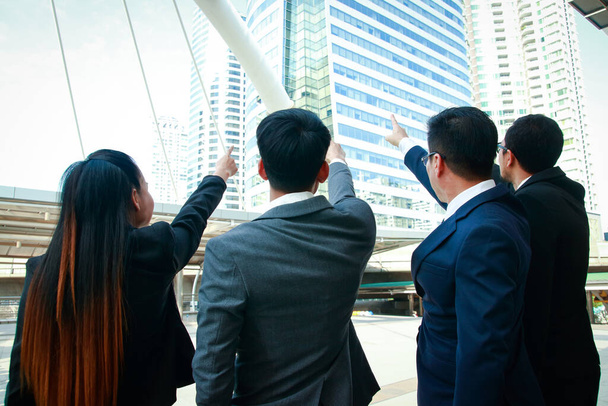 Ασιατική επιχειρηματική ομάδα στέκεται μαζί Σημείο το δάχτυλό σας προς τα εμπρός για να ολοκληρώσετε το στόχο. - Φωτογραφία, εικόνα