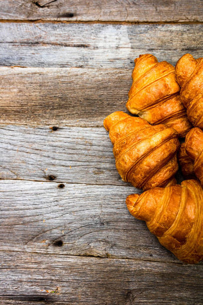 Lahodné čerstvé croissanty izolované na dřevěné desce. Francouzská snídaně koncept. - Fotografie, Obrázek