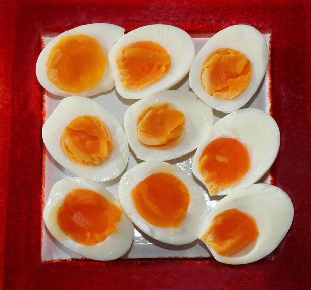 Mitades de huevo duro en una placa roja - Foto, Imagen