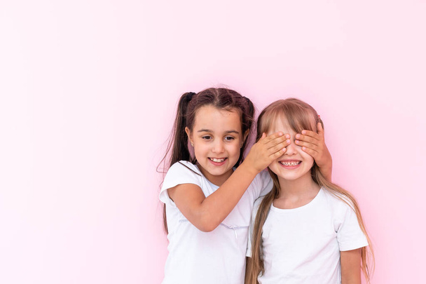 két kislány becsukja a szemét, meglepetést okozva, izgatott gyermek - Fotó, kép