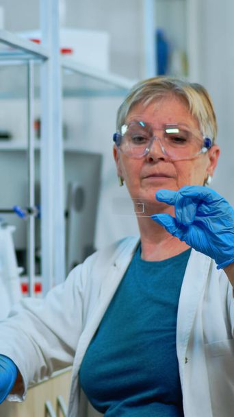 Técnico de laboratorio mujer mayor mirando la muestra de virus - Foto, Imagen