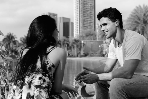 Young Hispanic couple relaxing in the park together - Foto, Imagem
