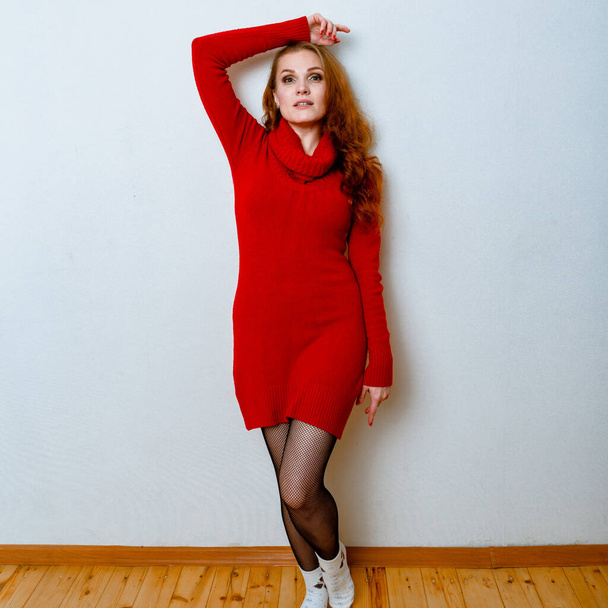 Portrait of ginger woman in red sweater in studio with isolated background.  - Foto, immagini