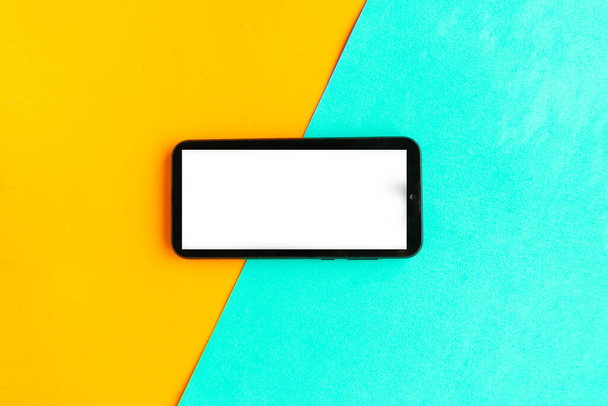 Мобільний телефон з білим макетним екраном на кольоровому геометричному фоні
.  - Фото, зображення