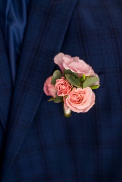 boutonniere con estilo en la chaqueta del novio, día de la boda, hermoso boutonniere de flores, concepto de boda - Foto, imagen