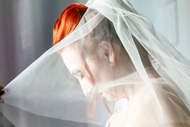 Beautiful young bride under a veil, close up - Фото, изображение