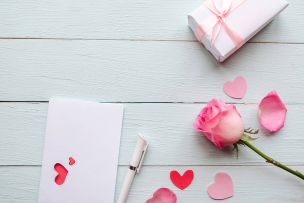 Rose, pudełko z prezentami i kartka z życzeniami na drewnianym stole. Walentynki kartka z życzeniami - Zdjęcie, obraz