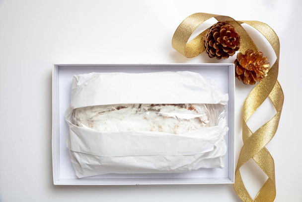 Christstollen Noel pastası beyaza izole edilmiş. Karton bir kutuda ve mevsimlik dekorasyonla sarılmış geleneksel Alman ekmeği. Dresden 'den Xmas hediyesi - Fotoğraf, Görsel