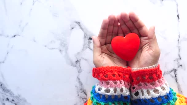  γυναίκες κρατώντας κόκκινη καρδιά σε πλακάκια φόντο πάνω προς τα κάτω  - Πλάνα, βίντεο