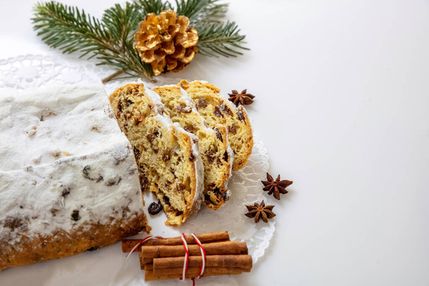 Christstollen slices on white background. Christmas stollen cake sweet german traditional bread, Seasonal dessert with raisins, nuts, spices, dried fruits and icing sugar - Photo, Image