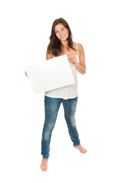 Full length portrait of a gorgeous smiling woman holding an empty billboard, isolated on white studio background - Photo, Image