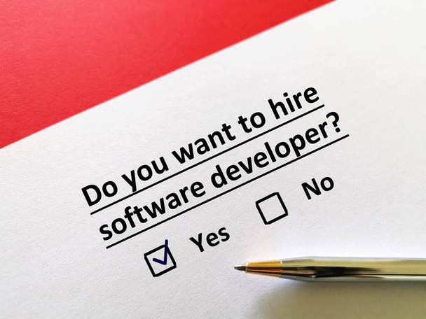 Una persona está respondiendo a la pregunta. Quiere contratar a un desarrollador de software. - Foto, Imagen