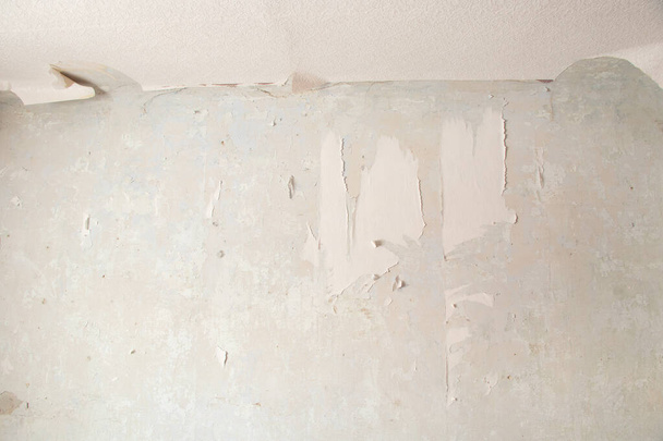 retirar papel pintado de papel viejo de la pared en una habitación de un edificio residencial, renovando un apartamento - Foto, imagen