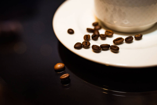 Granos de café aromáticos vigorizantes después de asar con una taza de café - Foto, imagen