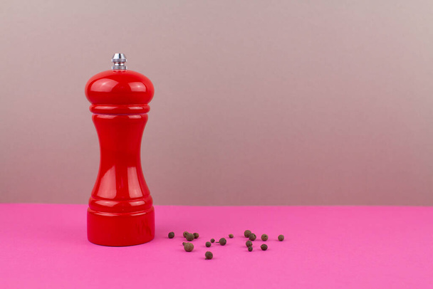 a red kitchen pepper shaker for ground pepper on the table - Zdjęcie, obraz