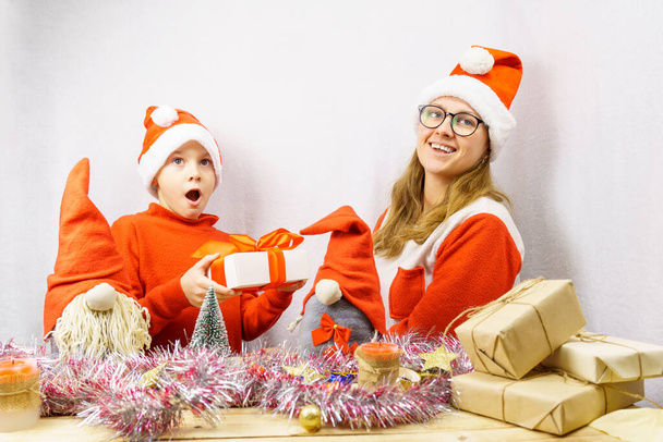 Здивований хлопчик в костюмі гнома отримує подарунок від дівчини з посмішкою в костюмі гнома. Скандинавські гноми. Різдвяні свята. - Фото, зображення