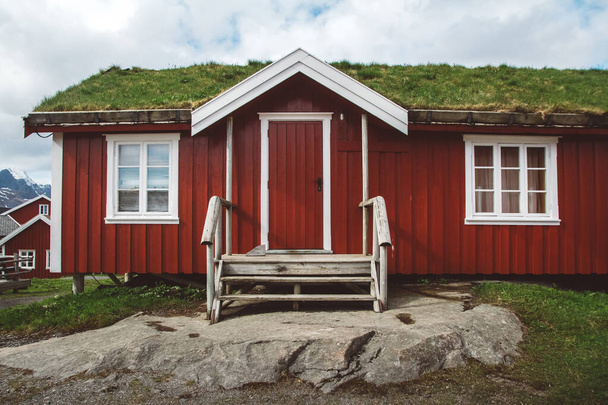 Norvégia rorbu házak piros és moha a tetőn táj skandináv utazási kilátás Lofoten-szigetek. Természetes skandináv táj. - Fotó, kép