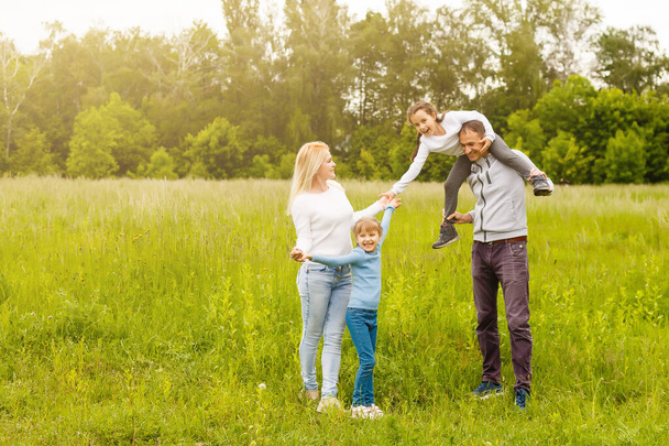Família feliz desfrutando a vida juntos no prado ao ar livre. - Foto, Imagem