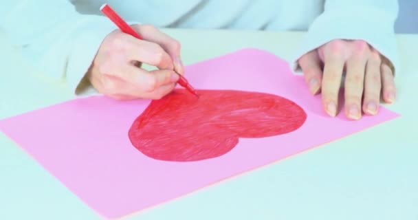 Το γυναικείο χέρι ζωγραφίζει μια κόκκινη καρδιά στο χαρτί. Σύμβολο αγάπης. Ημέρα του Αγίου Βαλεντίνου - Πλάνα, βίντεο