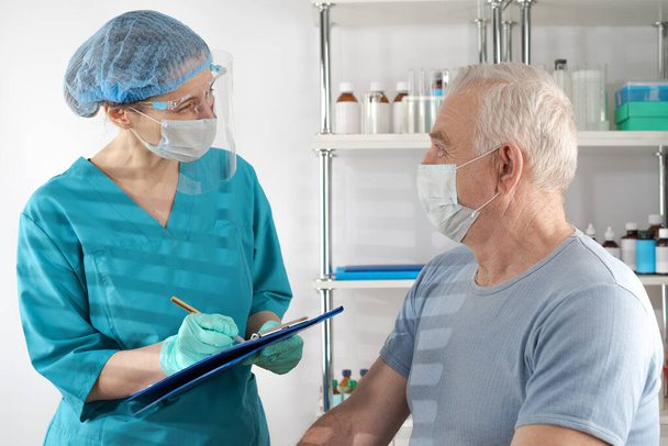Specjalistka od medycyny przesłuchuje starszego dorosłego mężczyznę. Przypadek szpitalnej opieki zdrowotnej. - Zdjęcie, obraz