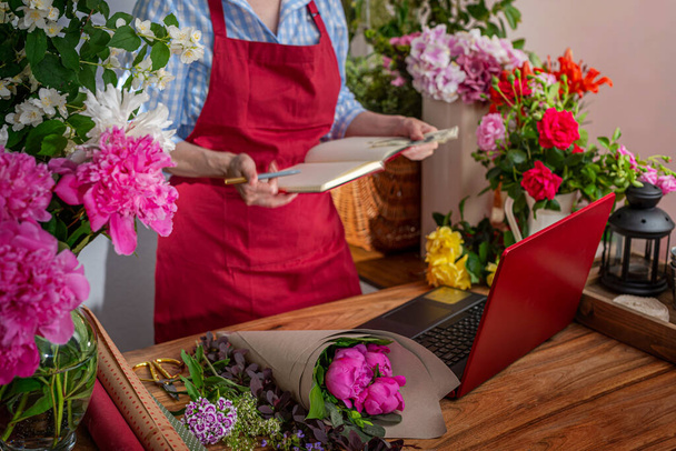 Crop view saller of flowers. Floristic business. Arrangement of bouquets. - Photo, Image