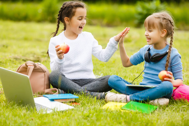 As alunas giras comem ao ar livre. Almoços saudáveis para alunos. Caixa de almoço com fruta. Almoço escolar. - Foto, Imagem
