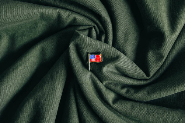 USA vlag pin badge op groene stof achtergrond. Bovenaanzicht. Kopieer, lege ruimte voor tekst. - Foto, afbeelding