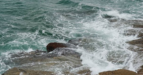 Oceaangolven spatten tegen rotsen aan - Foto, afbeelding
