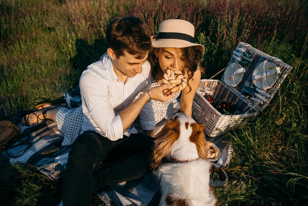 Kochająca się para urządza piknik z ukochanym psem. - Zdjęcie, obraz