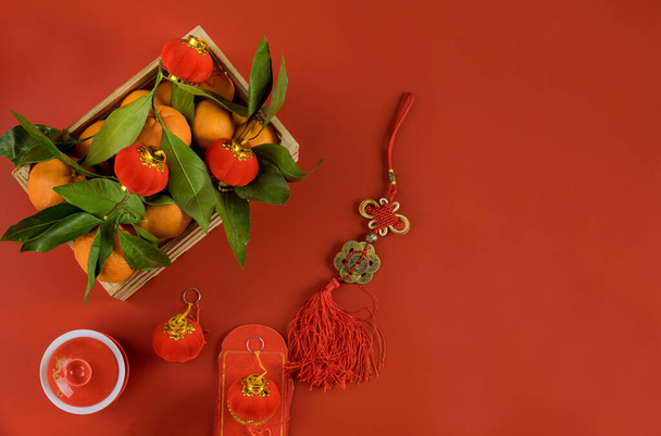 Dekorationen von Accessoires im chinesischen Neujahrsfest in traditionellen Containermandarinen auf rotem Hintergrund - Foto, Bild