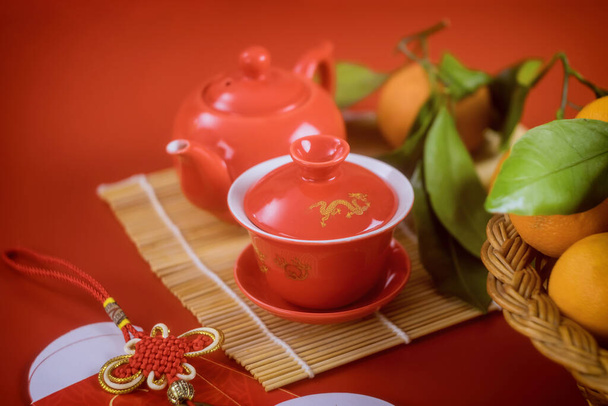 Maan traditionele lente seizoen Chinees Nieuwjaar feestelijke thee ceremonie met mandarijn oranje rode decoratie achtergrond op selectieve focus - Foto, afbeelding