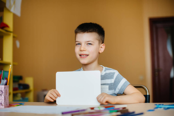 A school-age boy does homework at home. Training at school - Fotografie, Obrázek