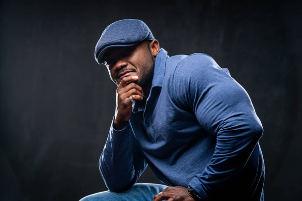 Professional african american sportsman posing on camera in casual clothes. Black studio background. - Foto, Imagem