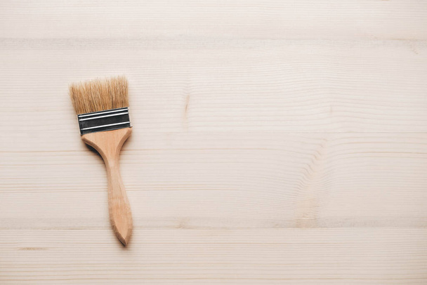 Paint brushes with a wooden handle and natural bristles on a wooden background. Repair concept. Top view. Copy, empty space for text. - Photo, Image
