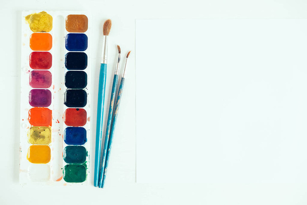 Set of watercolor paints and brushes for painting on a white background. Top view. Copy, empty space for text. - 写真・画像