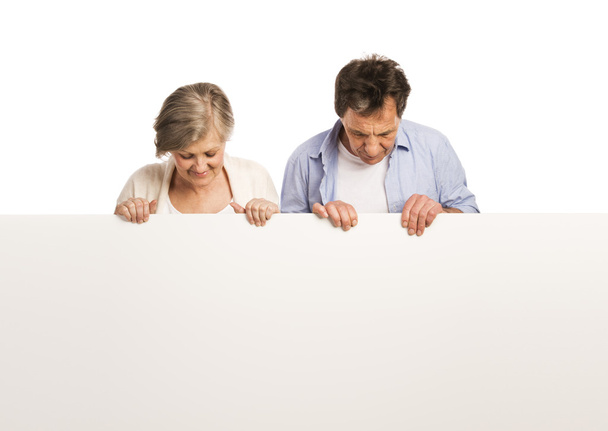 Senior couple with advertising board - Фото, зображення