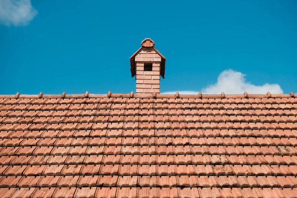 Vieilles tuiles sur le toit d'une maison avec cheminée sur fond de ciel. Lieu de texte ou de publicité. - Photo, image