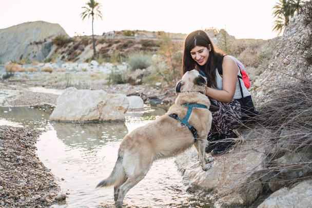 Een meisje met haar hond gelukkig in de rivier - Foto, afbeelding