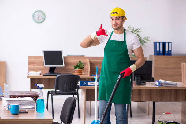 Young male contractor cleaning the office - Photo, Image