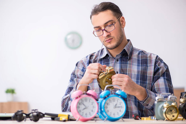 Joven relojero masculino trabajando en el taller - Foto, Imagen