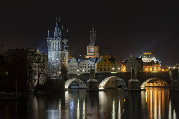 Most Karola na Wełtawie i światło od świateł ulicznych w centrum Pragi w zimie - Zdjęcie, obraz