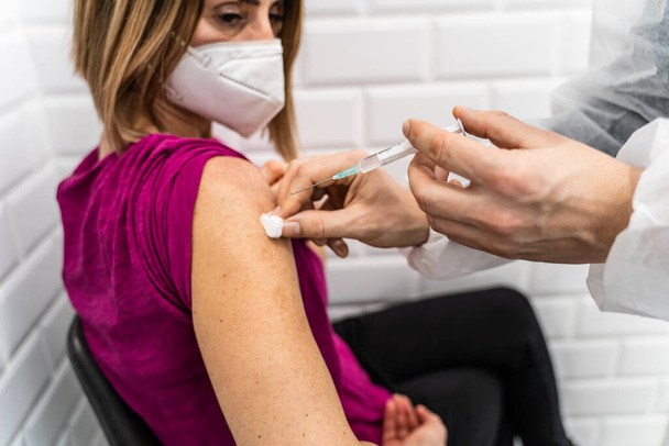 Aşı sağlık konsepti - Bilinmeyen doktor ya da sıhhiyenin elleri Corona virüsü kovid-19 HPV ya da hasta kolu için grip aşısı hazırlayan bir şırıngayı tutun - Fotoğraf, Görsel