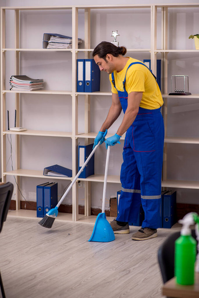 Giovane appaltatore maschile pulizia dell'ufficio - Foto, immagini