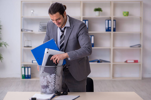 Fired young businessman with recycle bin in the office - Foto, Imagem